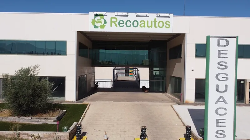 Fachada moderna de desguaces recoautos con entrada principal y señalización vertical