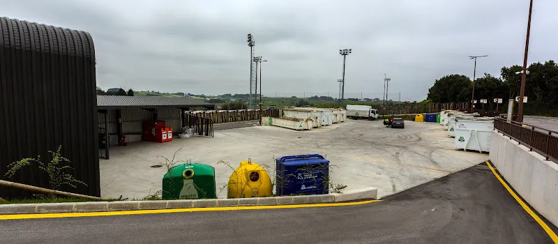 Vista panorámica del punto limpio carreno con contenedores de reciclaje verdes, amarillos y azules y grandes fardos de residuos