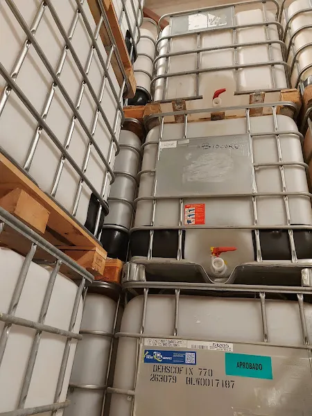 Contenedores IBC apilados en jaulas metálicas en almacén replasal